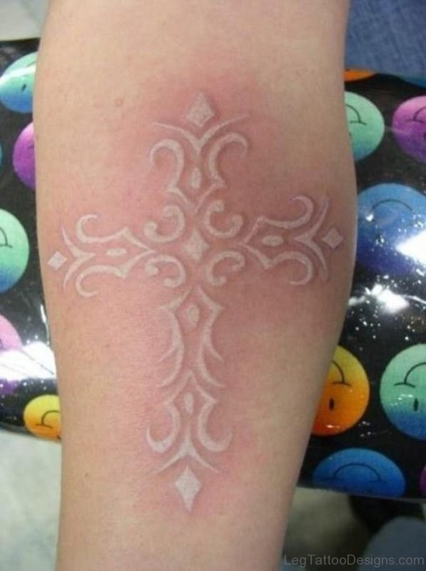 Elegant white ink cross tattoo on leg