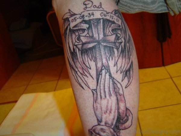 Wings Cross And Folding Hands Memorial Tattoo On Leg