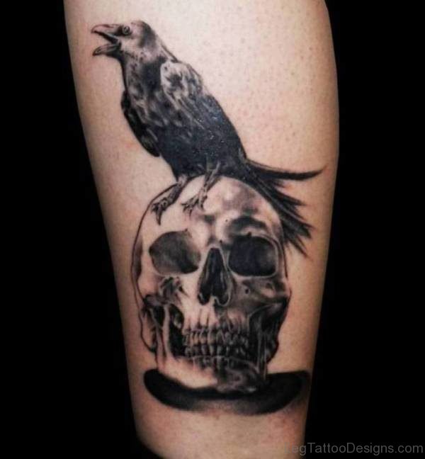 Crow Sitting On Skull Tattoo On Leg